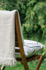 wooden chair with pillow in green garden outdoors, closeup