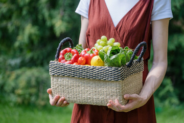 woman hold wicker basket with fresh vegetables and fruits