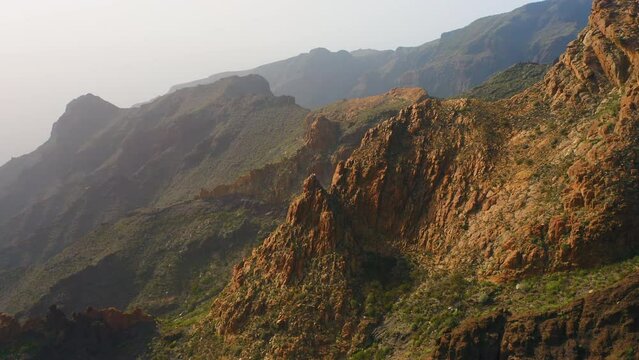 Sunset in mountains. Paradise for hikers. Beautiful trek to gorge, Risco Blanco. Buenavista del Norte. Great place for leisure activity. Aerial, clay rock. National Teno Park. Vegetation in spring.