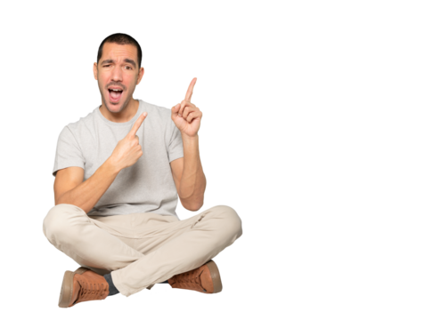 Amazed young man pointing up with his finger