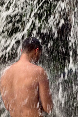 A man standing under a waterfall in Morocco