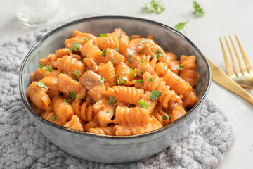 Fusilli pasta with chicken. Cooked in spicy sauce from tomatoes, onion, garlic with chicken meat