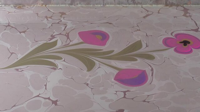 The art of marbling, which is an ornamental art. It is making patterns with paints on water condensed with tragacanth and transferring these patterns onto paper.