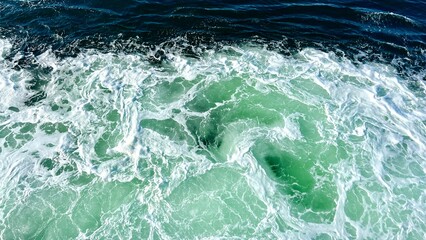 Obraz premium Bright green churning sea with white foam background for any text swatches of trasparent gel on green ash color background beauty hyaluronic acid or antibacterial gel. High quality photo