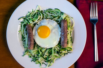 zucchini noodles with fried eggs and sausage