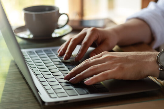 Close up image of woman hands typing on laptop computer keyboard and surfing the internet on office table, online, working, business and technology, internet network communication concept. 
