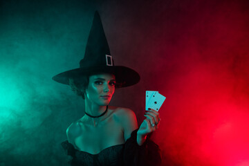 Photo of enchantress lady hold play cards bet gambling poker nightclub isolated on mystical lights...