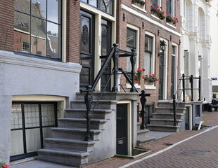 Amsterdam Groenburgwal Canal Street View with House Entrance Steps, Flowers and Reflection, Netherlands