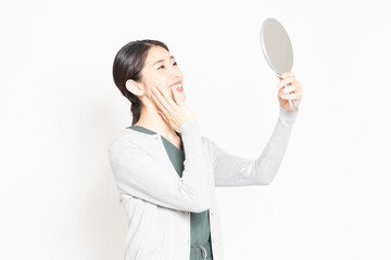 鏡を見て肌のチェックをする女性