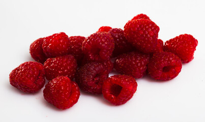Close up of ripe red raspberries on white surface, nobody