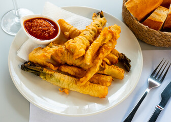 Fried calcots in tempura with romesco sauce. Dish of national Catalan cuisine
