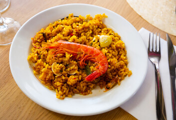 Delicious traditional Valencian seafood paella - savory rice dish with shrimps and clams