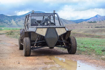 Buggy on a dirt road in the background of a mountain landscape