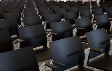 Naklejka premium Empty conference hall with rows of black plastic chairs