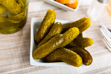 Little pickled cucumbers gherkins on plate, homemade pickles
