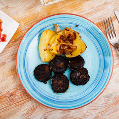 Fried rustic tasty blood sausage with potato served at plate, nobody