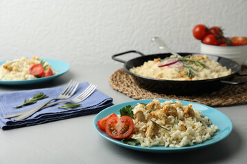 Delicious chicken risotto served on grey table