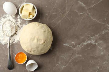 Flat lay composition with dough on marble table, space for text. Cooking pastries