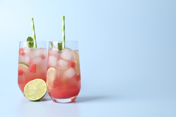 Tasty summer watermelon drink with lime in glasses on pale light blue background. Space for text