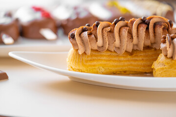 Custard cakes with chocolate cream and chocolate decor .Choux pastry. Summer desserts.Sweets and desserts. Baked goods and desserts.Eclairs cakes.