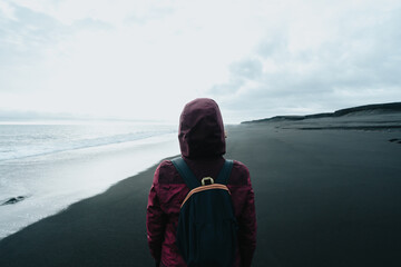 Female solo traveler in a black sand beach in Iceland diamond beach, during a sunny day. Exploring...