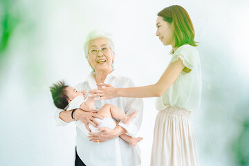 赤ちゃんを抱っこするシニア女性とお母さん