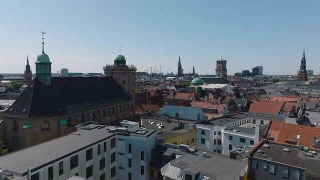 People enjoying view of city from height. Forwards fly along Trinitatis Church and Round Tower. Cityscape with historic landmarks. Copenhagen, Denmark