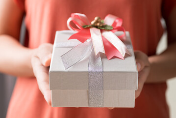 Silver gift box with ribbon in hand, Present for giving in special day and holiday