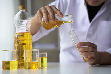 Close up view of industrial worker with vegetable oil quality test in the room.