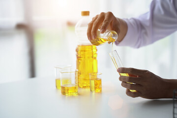 Close up view of industrial worker with vegetable oil quality test in the room.