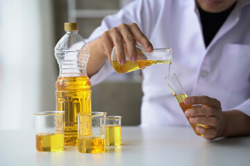Close up view of industrial worker with vegetable oil quality test in the room.