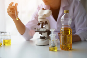 Close up view of industrial worker with vegetable oil quality test in the room.