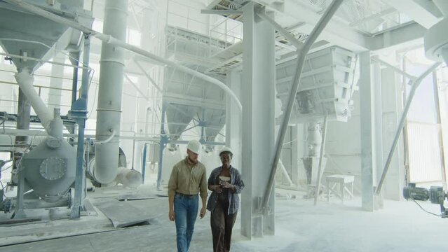 Overview shot of people working at natural stone processing and manufacturing plant with cement and granite everywhere