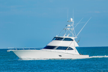 A sportfish motor yacht heads out to sea for a fishing trip - Powered by Adobe