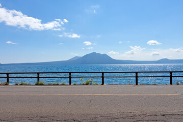 道路越しからみる水辺と山