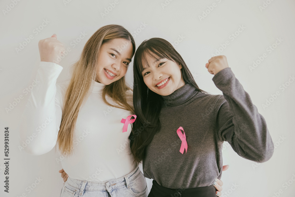 Wall mural Young Asian women with pink ribbons, breast cancer awareness, October pink concept, world cancer day