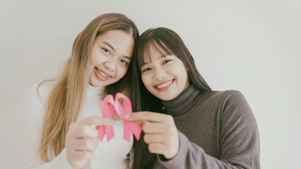 Young Asian women with pink ribbons, breast cancer awareness, October pink concept, world cancer day