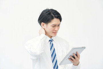 タブレットを見て悩むビジネスマン　白背景