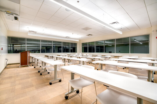 Example of a new empty nondescript office training, meeting room with desks, chairs, and white board.  Room could be in almost any office space.  Nobody included in image.