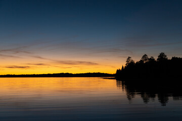 Fototapeta na wymiar Fading sunset glow at dusk over northern lake scene for magazine newsletter advertising layout design