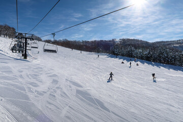 Fototapeta na wymiar 快晴のスキー場でスキーを楽しむ人