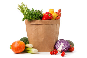 recyclable shopping paper bag full of fresh vegetables on white background.