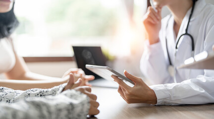 Professional medical doctor in white uniform gown coat interview counseling female patient.