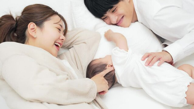赤ちゃんを寝かしつける両親　子育てイメージ