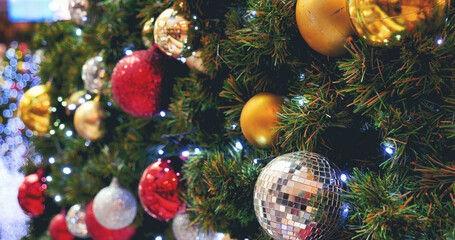 Fototapeta na wymiar Colourful glittering baubles ornament ball decorated christmas tree on holiday winter xmas happy new year festival celebration. Red, gold, silver ball on Christmas tree. Merry Christmas happy new year
