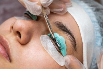 Close-up portrait of a woman on eyelash lamination procedure. 