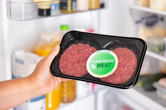 Woman holding package of plant-based hamburger meat