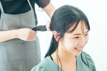 Naklejka premium 美容院でヘアアレンジでしてもらう女性 woman hair arrange