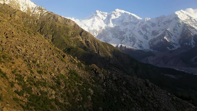 Drone shot of over mountain cliffs towards Nanga Parbat, Fairy Meadows Pakistan, snow-capped mountains, cinematic aerial shot