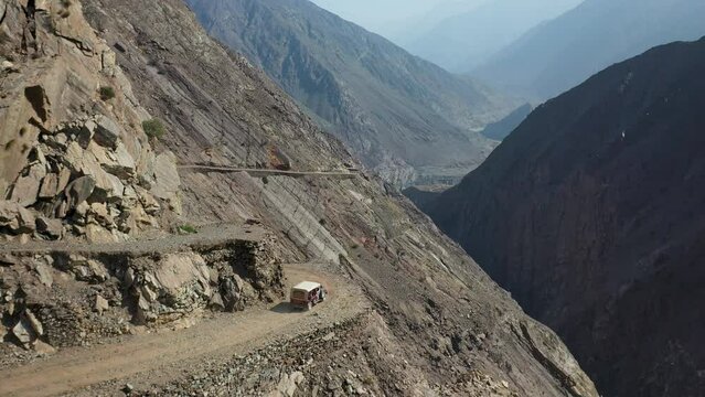 Aerial shot of vehicle on Fairy Meadows Road in Pakistan, second deadliest highway in the world, wide drone shot